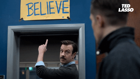 GIF of Ted Lasso pointing at the Believe sign in the AFC Richmond changing room.