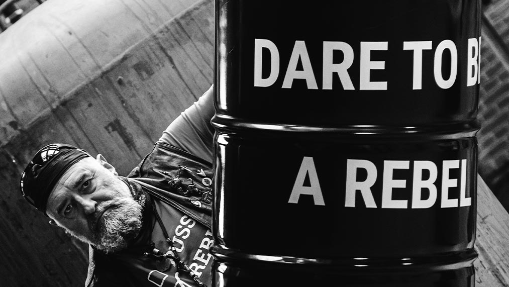 man with barrel with the slogan dare to be a rebel