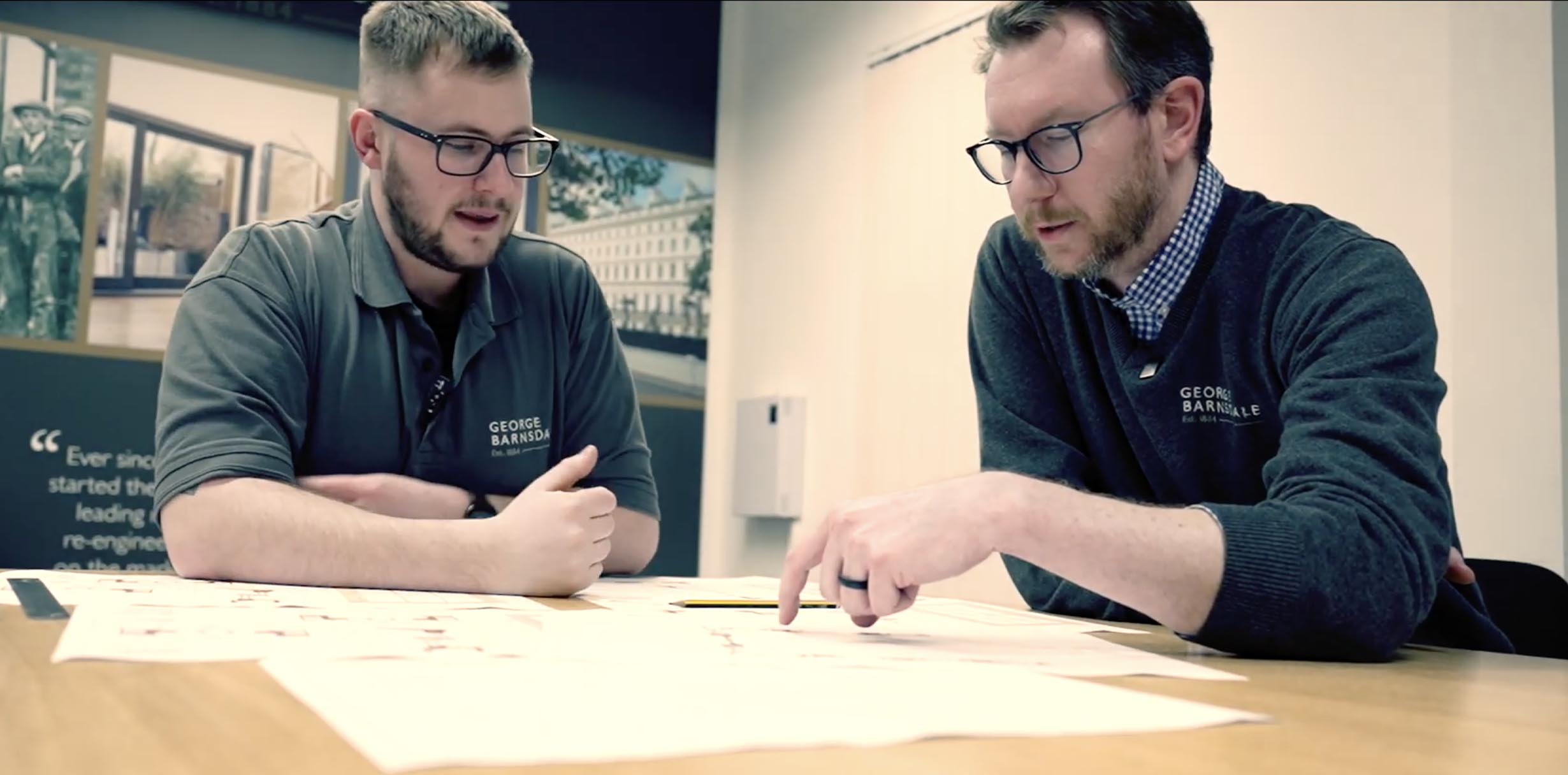 Video of two engineers looking at engineering plans and drawings